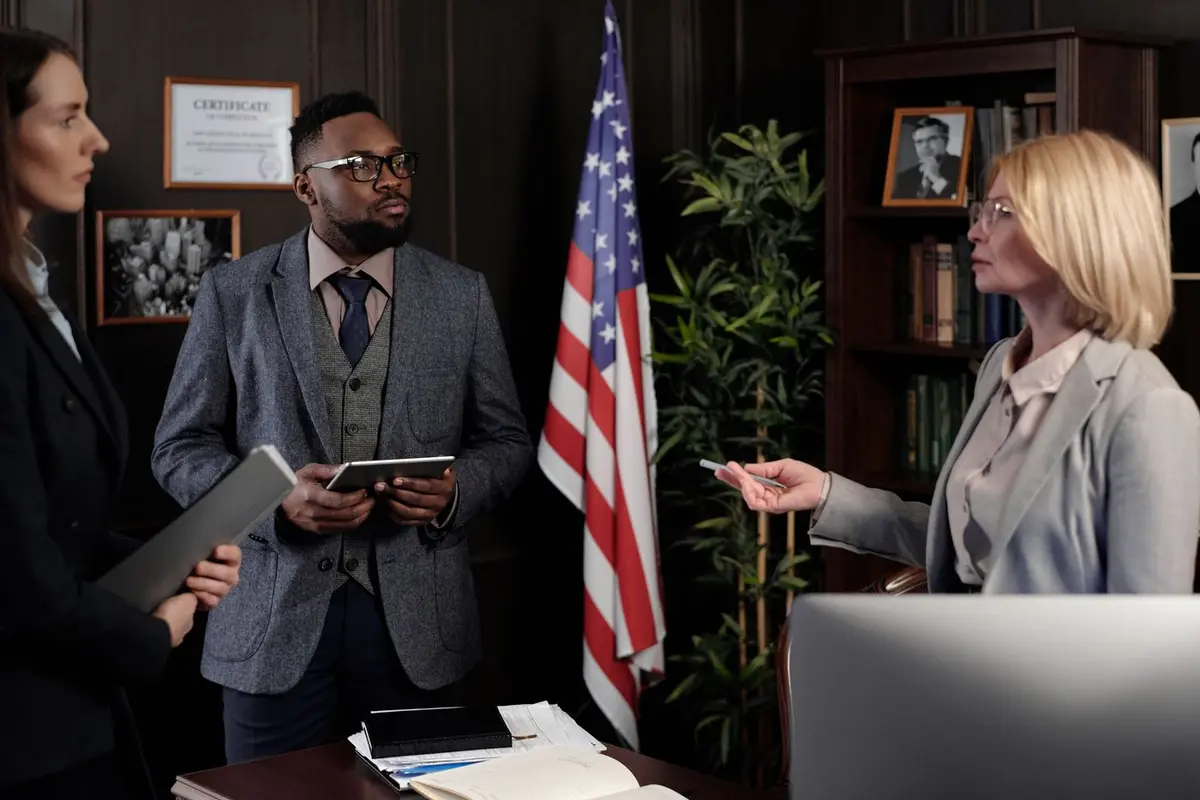 Three legal professionals discussing documents in a law office