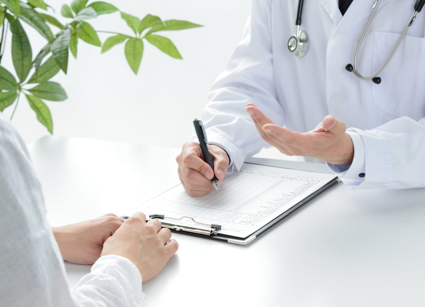 A doctor consulting with a patient and reviewing medical notes